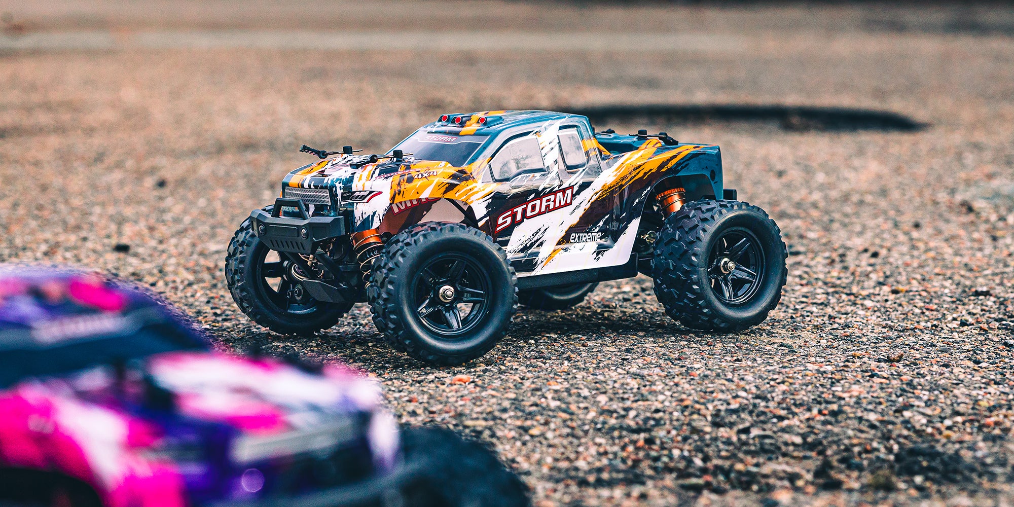 Grøn Hurricane 2.0 fjernstyret bil kører hurtigt gennem svinget på en støvet grusbane i dagslys.