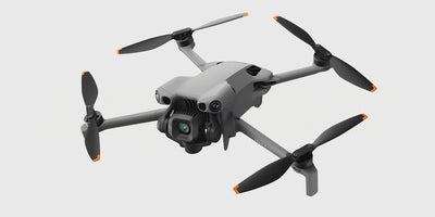 DJI Mini 5 Pro Fly More Combo med drone, fjernkontrol og tre batterier opstillet på en hvid baggrund.