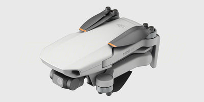 DJI Mini 4K Fly More Combo med drone, fjernbetjening, ekstra batterier og taske vist på hvid baggrund.