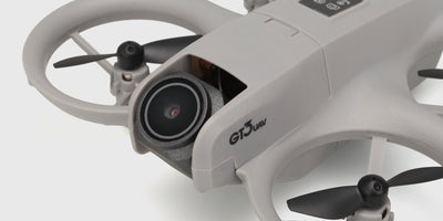 Sort Drone GT3 i luften set fra siden med kameraet vinklet nedad mod jorden.