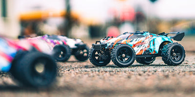 Grøn Hurricane fjernstyret bil kører hurtigt gennem støvet terræn i sollys.