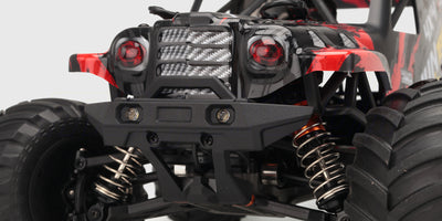 Rød Hurricane XL Monster Truck med store offroad-hjul i fuld fart gennem støvet terræn.