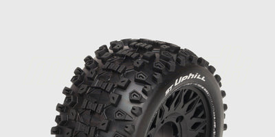 To sorte ST-Uphill dæk med groft dækmønster monteret på hvide fælge til fjernstyrede biler.