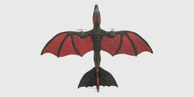 Grøn og gul Flying Dragon legetøjsdrage med vinger klar til at flyve.