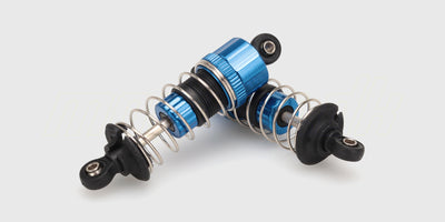 Blå HyperGo oliefyldte støddæmpere i metal til opgradering af fjernstyrede biler vist på hvid baggrund.