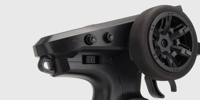 Sort HyperGo fjernstyring til børsteløse biler set skråt forfra med fokus på rat og knapper.