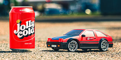 BTD Drifter fjernstyret mini driftbil i hvid kører på en grå indendørsbane med realistiske detaljer.