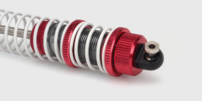 To sorte XLH Shocks støddæmpere i plast og metal til fjernstyrede biler vist på en hvid baggrund.