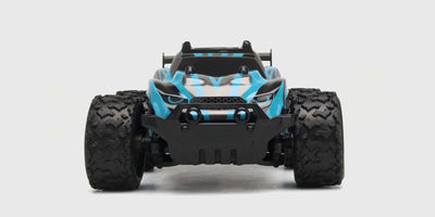 Grøn og sort Rapid Monster Truck med store offroad-hjul i høj fart på en grusvej.