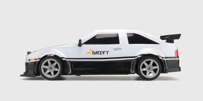 Grå Super Drifter fjernstyret driftbil med aerodynamisk vinge og detaljerede fælge set skråt forfra.