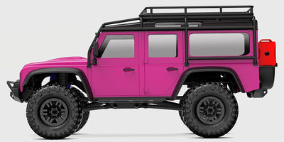 Lyserød Traxxas TRX-4M Land Rover Defender crawler set skråt bagfra på hvid baggrund.