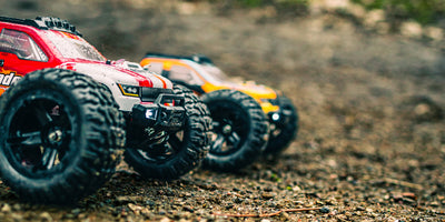 Grøn Tornado Brushless fjernstyret bil i fuld fart gennem mudder og vand på en offroad bane.