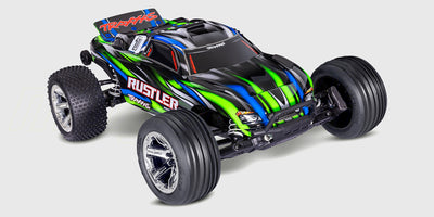 Blå Traxxas Rustler Brushless fjernstyret bil i høj fart på en grusvej med støvskyer efter sig.