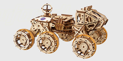 Mekanisk byggesæt i lyst træ med detaljerede tandhjul og bevægelige dele til modelbygning.