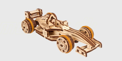 Detaljeret Ugears Compact Racer mekanisk byggesæt i træ med fungerende motor og synlige tandhjul.