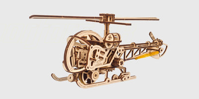 Mekanisk byggesæt af en mini-helikopter i lyst træ med detaljerede tandhjul og rotorblade.