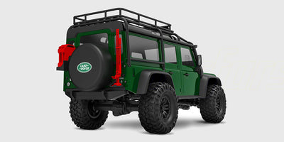 Grøn Traxxas TRX-4M Land Rover Defender crawler set skråt bagfra med reservehjul og tagbagagebærer.