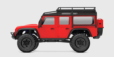 Rød Traxxas TRX-4M Land Rover Defender fjernstyret bil set fra siden på hvid baggrund.