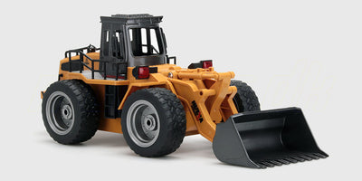 Gul fjernstyret gummiged med bevægelig skovl og sorte detaljer vist på hvid baggrund.