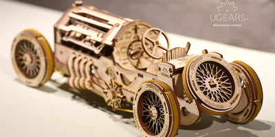 Ugears Grand Prix racerbil i træ, et detaljeret mekanisk byggesæt med synlige tandhjul og bevægelige dele.