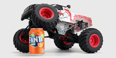 Quakeshock fjernstyret monstertruck med store hjul og blåt chassis i terræn.